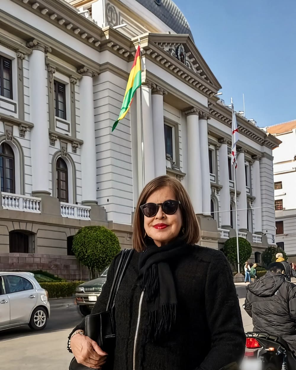 Marianella Cerball Vaca de Rowbottom, mujer de 72 a&ntilde;os, de pie, con abrigo oscuro y lentes de sol, frente a una sede judicial.